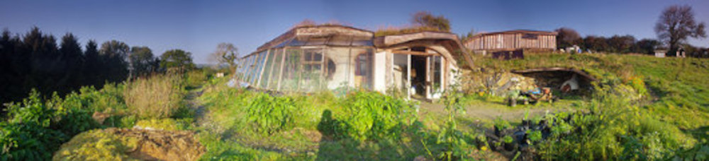 Простой и дешевый обвалованный экологический дом, южный фасад и окружающий ландшафт